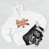The Printify PahaQue Unisex Premium Pullover Hoodie in white, featuring a cozy fleece lining and Bahà Que Wilderness print, is paired with folded black jeans, a white belt, and gray sneakers on a light gray surface.
