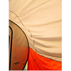 Close-up of a beige, orange, and white tent showing its fabric texture and seams, with part of a NuCamp TAB 360 Trailer Awning by Paha Que Custom and its teardrop camper visible on the left.