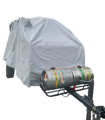 A vehicle is protected by a Paha Que Custom Campinawe Trailer Cover made of heavy-duty MagnaTuff fabric, with a front metal rack holding two strapped-down beer kegs—one silver, one striped.