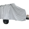 A Campinawe Trailer covered with the PahaQue Custom Heavy Duty MagnaTuff Fabric Trailer Cover features weather-proof, breathable material, a zippered side door, and reveals the metal tank, tow hitch, and black wheels at the front.