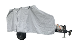 A Campinawe Trailer covered with the PahaQue Custom Heavy Duty MagnaTuff Fabric Trailer Cover features weather-proof, breathable material, a zippered side door, and reveals the metal tank, tow hitch, and black wheels at the front.