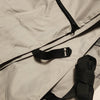 Close-up of the Paha Que Custom Bushwhacker Plus Trailer Cover bag (fits 15DS/15FK, Made in USA) in light gray fabric, featuring detailed stitching, a black zipper, and overlapping black adjustable straps with buckles.