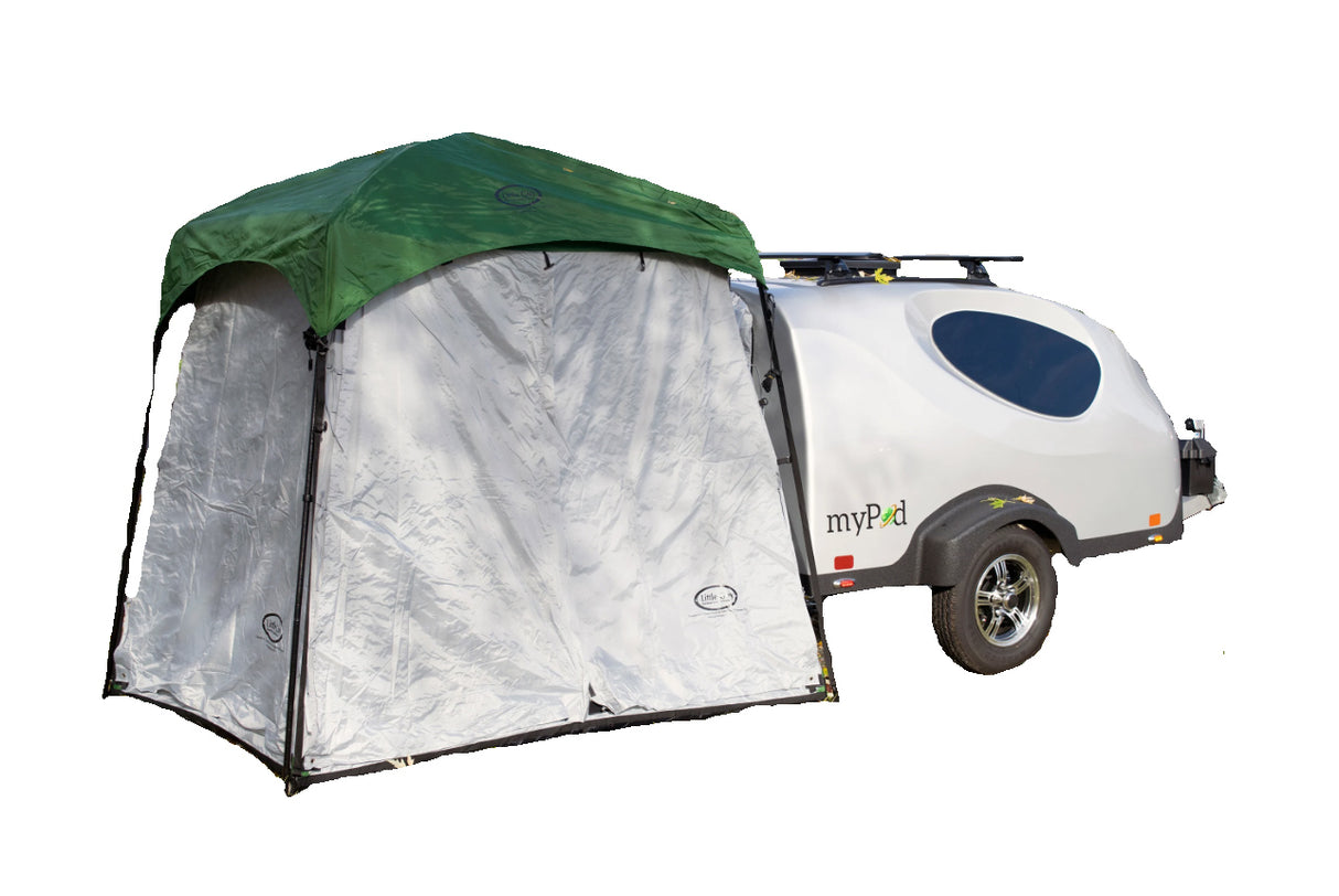 A compact white teardrop camper displays the Paha Que Custom 5x7 Trailer Side Tent Screen Room in green and silver at its entrance, adding extra space for relaxing or storage, all set against a plain white background.