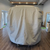 A large gray Paha Que Custom Happier Camper HC1 Cover made of durable MagnaTuff fabric stands on wheels in a modern office with wood floors and plants.