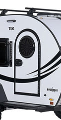 Close-up of the side door of a white teardrop camper trailer with black accents, featuring a Paha Que Custom Toy Hauler Mesh Door/Solid Room Divider for insect protection; the words T@G and BOONDOCK are visible on the exterior.