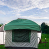 The Paha Que Custom 10x10 Side Mount Screen Room Tent for camping is set up on grass in front of a white camper trailer, with trees in the background and a partly cloudy sky above.