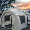 A Paha Que Custom NuCamp TAB 320 Trailer Side Tent for TAB and Boondock Trailers is set up outside near a tall tree, with camping supplies placed beside it and mountains plus a sunset sky in the background.