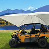 A PahaQue Wilderness All Purpose Portable Vehicle Awning for Cars, SUVs, Trucks, and Side by Sides is set up on grass near a mountain lake, surrounded by trees under a clear blue sky.
