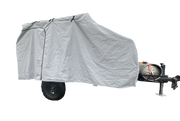 A Campinawe Trailer covered with the PahaQue Custom Heavy Duty MagnaTuff Fabric Trailer Cover features weather-proof, breathable material, a zippered side door, and reveals the metal tank, tow hitch, and black wheels at the front.