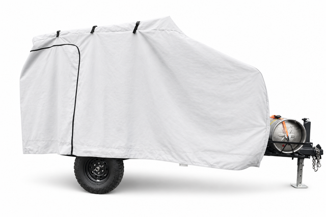 The Campinawe Trailer Cover by Paha Que Custom features heavy-duty MagnaTuff fabric that is weatherproof and breathable, shielding your small trailer while allowing access to the wheel, hitch, and front-mounted propane tank.