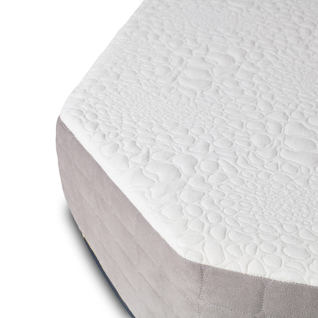 Close-up of the Journey Mattress by Paha Que Custom, a medium firm design with a white textured top featuring a pebble-like pattern, cooling gel memory foam, and light gray fabric sides.