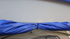 A close-up of the Forest River R-Pod Trailer Side Tent by PahaQue, showing a blue fabric secured with a black hook for easy setup—highlighting Paha Que Custom’s enhanced camping comfort against a light grey background.