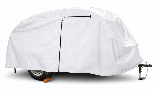 A compact trailer is fully protected by a PahaQue Wilderness So-Cal Teardrops Sierra Trailer Cover, with a black zipper, part of the wheel and hitch visible, and one wheel resting on a wooden block.