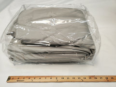 A folded gray Colorado Teardrops Summit Pinnacle Trailer Cover by PahaQue Wilderness, made from durable MagnaTuff fabric, is shown in clear packaging on a white surface next to an 18-inch wooden ruler for scale.