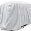 A large vehicle is fully covered with the Paha Que Custom Happier Camper HC1 Cover, a light gray custom-fit trailer cover that offers weather protection. Only the outline and part of the wheels are visible underneath.