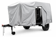 The compact trailer is protected by the Paha Que Custom Xpedition Trailer Cover for Ultimate Protection and Longevity, which features a light gray custom fit, zippered opening, and reveals the black door and frame while ensuring superior weather protection.