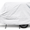 A 6x13 Squaredrop Trailer is protected by the Paha Que Custom Squaredrop Trailer Cover made of heavy-duty MagnaTuff fabric in white, concealing its shape while leaving the wheel, hitch, and support legs visible for easy access.