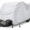 A UKAN Camp 590G/585G 5x9 utility trailer by PahaQue Wilderness features a white custom-fit cover for protection, black metal frame, front storage box, and four stabilizing legs, parked on a flat surface.