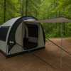 A spacious gray and black Paha Que Custom NuCamp TAB 360 Trailer Side Tent for Enhanced Camping Experience, with an extended canopy and open door, stands in a lush green forest clearing surrounded by tall trees.