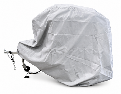 A large trailer is fully covered with the Ushi Chuck MAX Trailer Cover by PahaQue, offering heavy-duty weatherproof protection, while part of the metal hitch and wheel remain visible beneath the gray Paha Que Custom tarp.