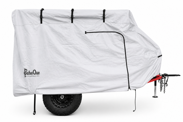 The PahaQue Wilderness Zion Off Road Trailer Cover, made from heavy-duty MagnaTuff fabric, features black straps, a zipper, and the PahaQue logo. It offers custom-fit weather protection for your trailer while partially revealing its tire and hitch.