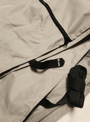 Close-up of a gray MagnaTuff fabric bag with black zipper, stitching, and an adjustable strap with a plastic buckle. The durable material resembles that of the Paha Que Custom NuCamp TAG Trailer Cover by PahaQue, known for heavy-duty weatherproof protection.