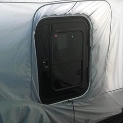 A close-up of a black RV door with a window, installed in the Paha Que Custom 5x7 Trailer Side Tent Screen Room for Camping and Outdoor Adventures. The enclosure fabric fits snugly, adding extra comfort to your camping setup.