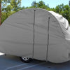 A NuCamp TAB 400 trailer, parked among green trees, is protected by a fitted gray Paha Que Custom weather-proof cover with only the wheels visible beneath it.