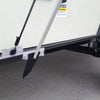 A close-up shows the Paha Que Custom R Pod Trailer Visor rod secured to the trailer frame with padding and tape, next to a rugged tire on concrete. Above this setup, a caution label is partially visible.